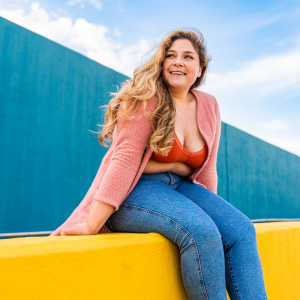 young woman sitting on a colorful wall enjoying the outdoors